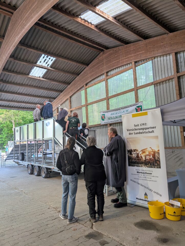 Interessierte lassen sich von fachkundigen Vorstandsmitgliedern die Funktion des neu angeschafften Badewagens für Schafe erklären. (© Schafzüchtervereinigung NRW)